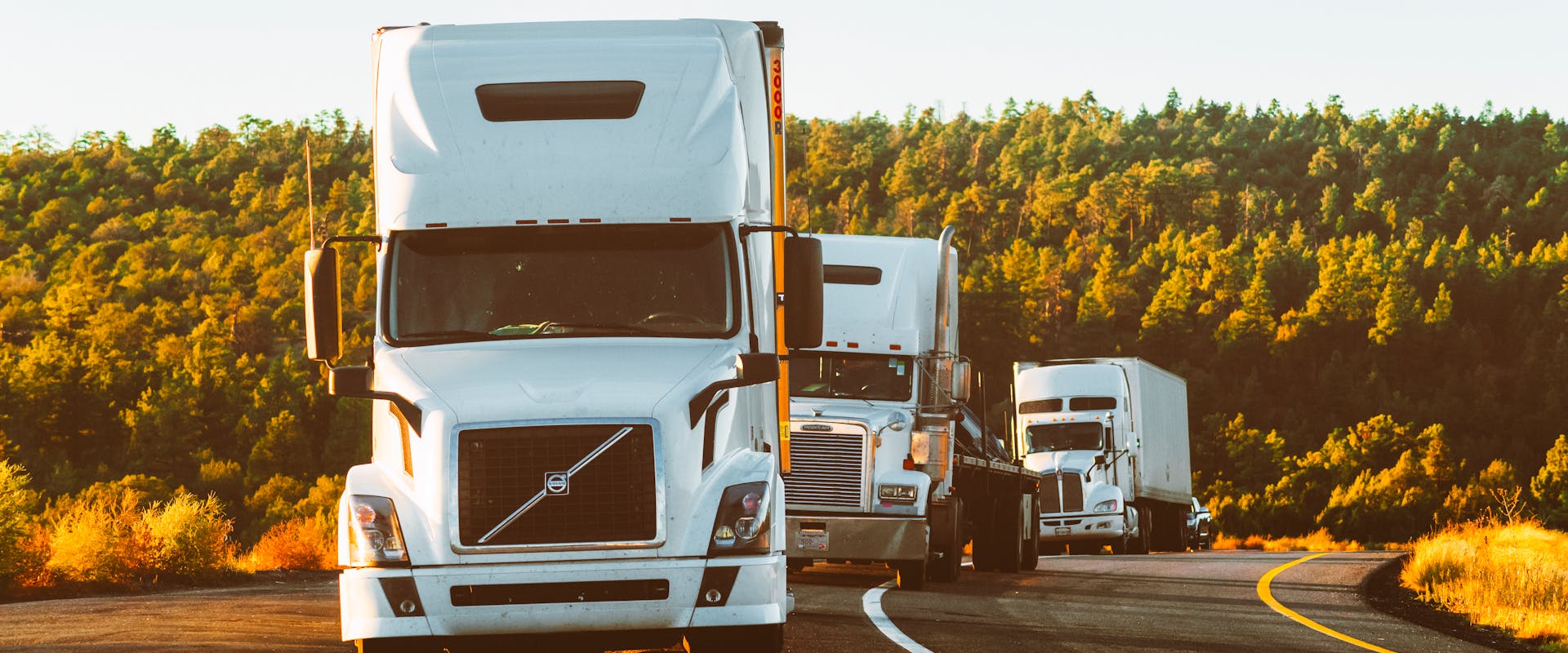 Semi trucks on highway at golden hour